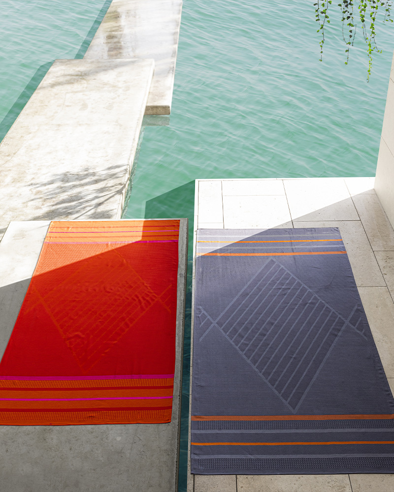 Serviettes de plage rouge et marine au bord de l'eau