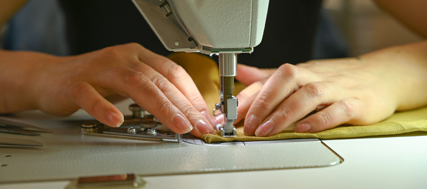 Mains d'une couturière à la machine à coudre